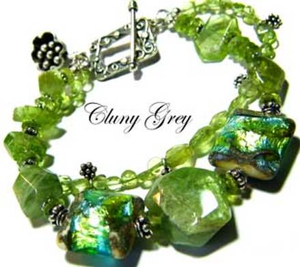 Peridot bracelet of two strands with lamp worked beads, sterling silver and flower charm.